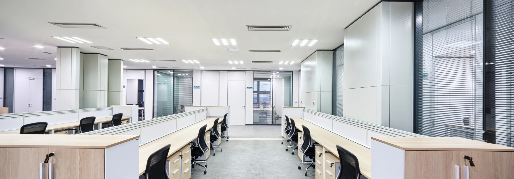 Modern office workspace layout with desks, ergonomic chairs and storage cabinets in Malaysia